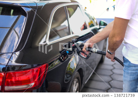 Driver Refueling Black Car With Fuel Nozzle At Gas Station Energy Transportation Concept 138721739