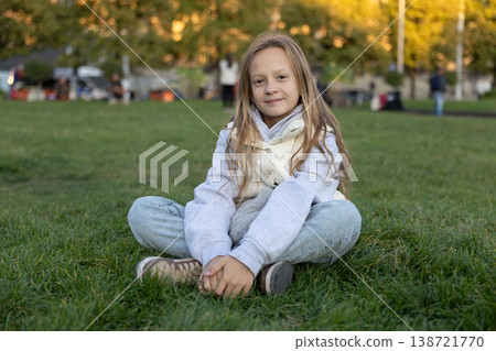 Smiling Girl Sitting On Grass Park Portrait Childhood Lifestyle Smiling Girl Sitting On Grass Park Portrait Childhood Lifestyle 138721770