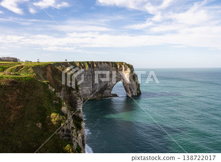 Etretat cliff arch with coastal grass and turquoise sea in Normandy France 138722017