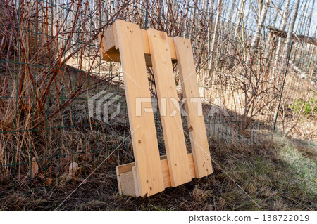Wooden pallet leaning against wire fence outdoors rustic storage and logistics concept 138722019