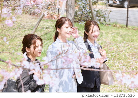 Three young female new employees walking under cherry blossoms - a spring business scene - freshmen in suits 138723520