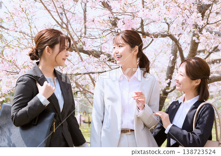 Three young businesswomen chatting under the cherry blossoms: Springtime new beginnings and colleagues at work. Three young businesswomen chatting under the cherry blossoms: Springtime new beginnings and colleagues at work. 138723524
