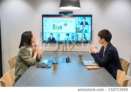 一位來自IT公司的男士和一位女士正在會議室的大顯示器上進行線上會議。 一位來自IT公司的男士和一位女士正在會議室的大顯示器上進行線上會議。 138723898