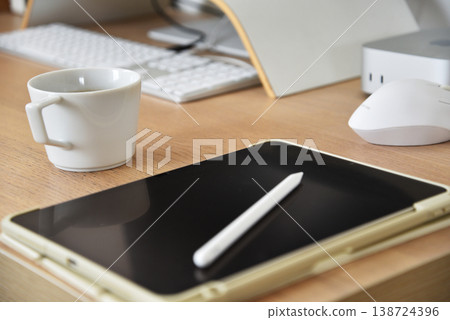 一張桌子上放著平板電腦、鋼筆和咖啡杯。 一張桌子上放著平板電腦、鋼筆和咖啡杯。 138724396