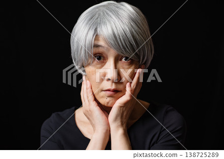 一位頭髮花白的老婦人，她很擔心自己的皮膚老化問題。 138725289