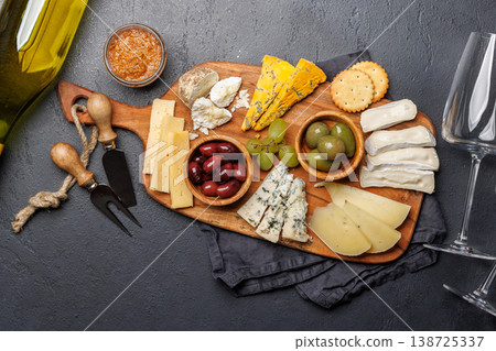Cheese board with assorted cheeses and olives Cheese board with assorted cheeses and olives 138725337