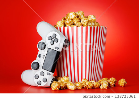 Popcorn and gamepad on red background Popcorn and gamepad on red background 138725361