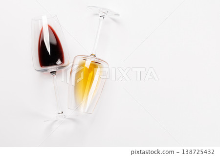 Wine glasses with red and white wine lying on white background 138725432