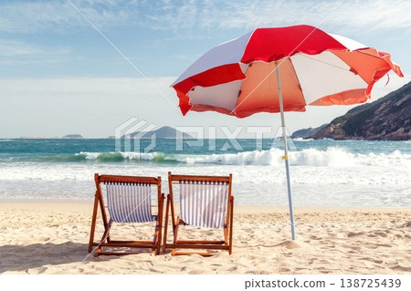 Beach loungers and umbrella by the sea Beach loungers and umbrella by the sea 138725439