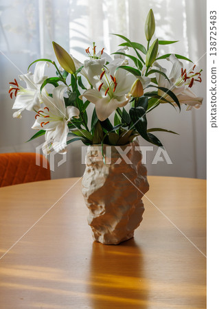 White Lily Flowers in Vase on Wooden Table White Lily Flowers in Vase on Wooden Table 138725483
