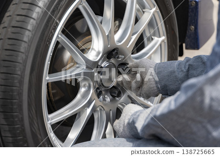 The tire installation process involves loosely tightening the wheel nuts by turning them with your fingers. The tire installation process involves loosely tightening the wheel nuts by turning them with your fingers. 138725665