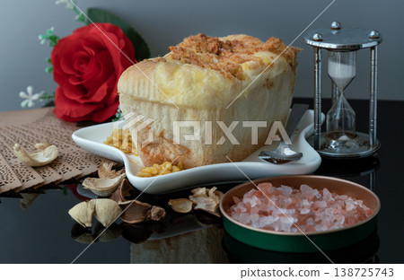 Presented on a star-shaped ceramic plate, this artisanal loaf is finished with a golden layer of melted cheese and flavorful dried pork floss. 138725743