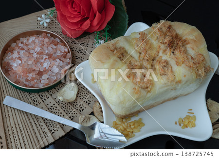 Resting on a star-shaped white plate, this soft, golden-brown loaf features a savory topping of pork floss and melted cheese. Resting on a star-shaped white plate, this soft, golden-brown loaf features a savory topping of pork floss and melted cheese. 138725745