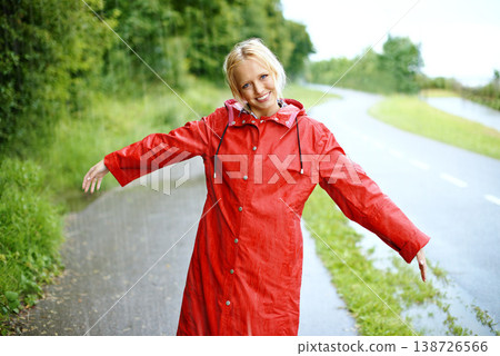 Woman, smile and raincoat in rain with arms, wet and cold from weather, winter and nature. Happy female person, fashion and red jacket in storm, rainfall and protection from water, face and outdoors Woman, smile and raincoat in rain with arms, wet and cold from weather, winter and nature. Happy female person, fashion and red jacket in storm, rainfall and protection from water, face and outdoors 138726566