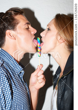 Lollipop, lick and couple on a white background with snack share for love, bonding and playful. Dating, happy relationship and isolated of man and woman with sweets, sugar treats and candy in studio Lollipop, lick and couple on a white background with snack share for love, bonding and playful. Dating, happy relationship and isolated of man and woman with sweets, sugar treats and candy in studio 138726609
