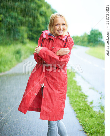 Raining, portrait and young woman with coat in nature, road or street for winter in countryside. Smile, positive attitude and female person from Canada in drizzle or storm weather in outdoor forest. 138726825