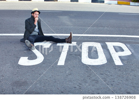 Man, asphalt and stop or sign on road, danger and sitting by symbol, bad habits and addiction to drugs. Male person, nicotine and danger or risk, street and warning of cigarette, awareness and quit Man, asphalt and stop or sign on road, danger and sitting by symbol, bad habits and addiction to drugs. Male person, nicotine and danger or risk, street and warning of cigarette, awareness and quit 138726908