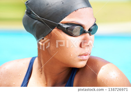 Woman, face and athlete swimming with goggles in sunshine for challenge, underwater sports and training. Serious swimmer thinking in pool of performance, exercise and triathlon competition in summer Woman, face and athlete swimming with goggles in sunshine for challenge, underwater sports and training. Serious swimmer thinking in pool of performance, exercise and triathlon competition in summer 138726971