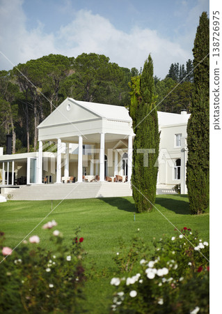 Landscape, garden design or hotel with evergreen trees in nature for growth, sustainability and greenery in summer. Manor, lawn or environment background with grass, scenery and house in countryside Landscape, garden design or hotel with evergreen trees in nature for growth, sustainability and greenery in summer. Manor, lawn or environment background with grass, scenery and house in countryside 138726975