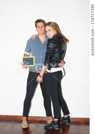 Portrait, education and chalkboard with a hipster couple on white wall background together for date. Fashion, love or learning space with a young man and woman on a school campus for relationship 138727386