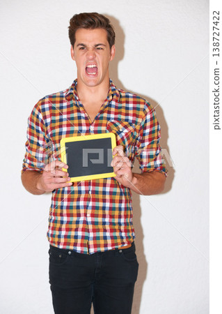 Screaming, angry and man with blackboard for education in studio isolated on white background for mockup, advertising or marketing. Blank chalkboard, space and frustrated person with stress at school Screaming, angry and man with blackboard for education in studio isolated on white background for mockup, advertising or marketing. Blank chalkboard, space and frustrated person with stress at school 138727422