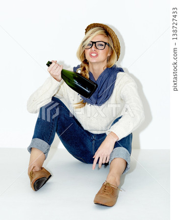 Champagne, drunk or woman on floor with hangover from hipster, rebel or event in studio. Relax, festive or female person drinking alcohol or beverage in bottle for New Year on white background 138727433
