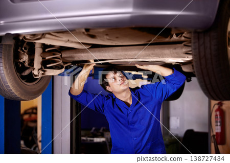 Car, inspection or repair with a mechanic man in a garage for a report on a vehicle service for insurance. Maintenance, professional and a young professional engineer in a workshop for assessment 138727484
