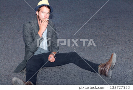 Portrait, outdoor and man smoking, hipster on the ground and relax with fashion, casual and stylish. Person, outdoor and guy with cigarette, tobacco and smoke with casual, trendy and outfit clothes 138727533