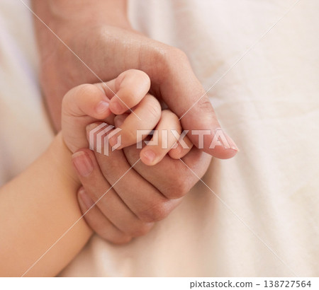 Parent, baby and holding hand for comfort on bed for love, trust or support in bond. Person, infant and caring with touch for child development, growth or health in wellness for quality time together Parent, baby and holding hand for comfort on bed for love, trust or support in bond. Person, infant and caring with touch for child development, growth or health in wellness for quality time together 138727564