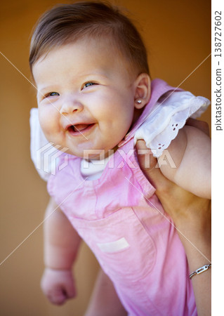 Hands, holding and portrait of a baby for playing, laughing and bonding with a parent in a house. Happy, playful and a infnt, child or girl kid in the arms of a mother for trust, care and fun 138727602
