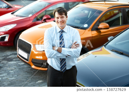 Portrait, smile and a man arms crossed at a dealership for car sale in a commercial parking lot. Business, luxury and automobile trade with a happy young salesman outdoor for transport service Portrait, smile and a man arms crossed at a dealership for car sale in a commercial parking lot. Business, luxury and automobile trade with a happy young salesman outdoor for transport service 138727629
