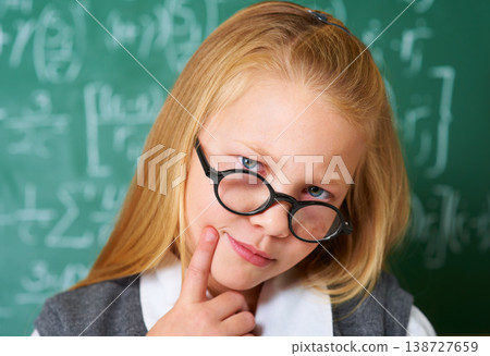 Portrait of student, nerd and kid thinking by chalkboard in class for learning knowledge, education and study math. Face, glasses and geek at school, blonde girl and child in classroom in Switzerland Portrait of student, nerd and kid thinking by chalkboard in class for learning knowledge, education and study math. Face, glasses and geek at school, blonde girl and child in classroom in Switzerland 138727659