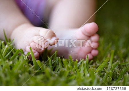 Feet, closeup and baby outdoor on grass, lawn and newborn toes on field in nature. Child, development or foot touching green, plants and close up of kid legs in garden with sensory experience 138727866