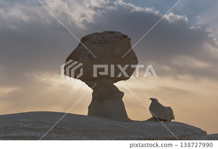 Mushroom-shaped rocks silhouetted against the light, creating a dramatic landscape of light and shadow. Mushroom-shaped rocks silhouetted against the light, creating a dramatic landscape of light and shadow. 138727990