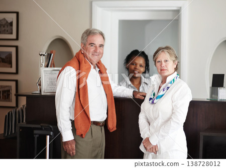 Hotel, portrait and senior couple at reception for booking, vacation or freedom at luxury accommodation. Travel, hospitality and face of old people with female receptionist appointment or payment Hotel, portrait and senior couple at reception for booking, vacation or freedom at luxury accommodation. Travel, hospitality and face of old people with female receptionist appointment or payment 138728012