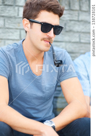 Man in sunglasses, smoking pipe and thinking, relax outdoor and fashion in urban city by wall. Smoke, cool person in glasses or style, serious or hipster in casual clothes, tshirt and sitting in town Man in sunglasses, smoking pipe and thinking, relax outdoor and fashion in urban city by wall. Smoke, cool person in glasses or style, serious or hipster in casual clothes, tshirt and sitting in town 138728101