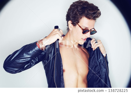 Man, sunglasses and leather jacket in studio with spotlight, fashion or thinking with punk style by background. Rockstar, fashion and halo with confidence, attitude or jewelry for trendy aesthetic 138728225