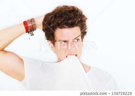 Thinking, confused and a man biting his tshirt in studio isolated on white background for crazy style. Face, doubt or expression with a young model scratching his head, looking clueless about an idea Thinking, confused and a man biting his tshirt in studio isolated on white background for crazy style. Face, doubt or expression with a young model scratching his head, looking clueless about an idea 138728229