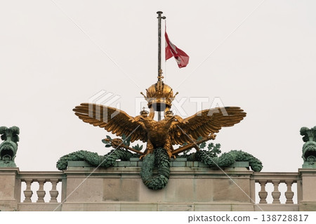 Golden double headed imperial eagle with crown atop Hofburg Palace in Vienna, Austria Golden double headed imperial eagle with crown atop Hofburg Palace in Vienna, Austria 138728817