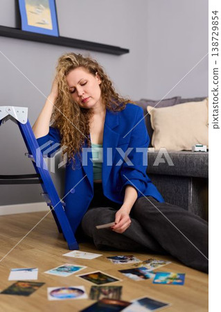 Peaceful woman seated among postcards in gentle indoor light 138729854