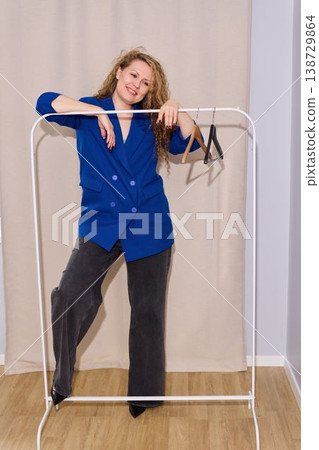 Person demonstrating energetic poses near wardrobe with totebag and hangers Person demonstrating energetic poses near wardrobe with totebag and hangers 138729864