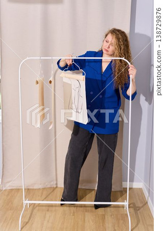 Woman setting up sustainable clothing display in studio Woman setting up sustainable clothing display in studio 138729876