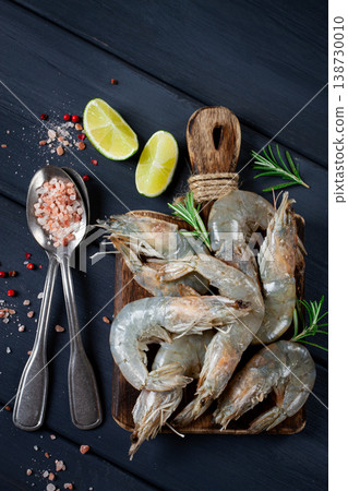Fresh raw, white-footed shrimp, tiger prawns vannamei, on a wooden cutting board, with lime slices, and seasonings, Fresh raw, white-footed shrimp, tiger prawns vannamei, on a wooden cutting board, with lime slices, and seasonings, 138730010