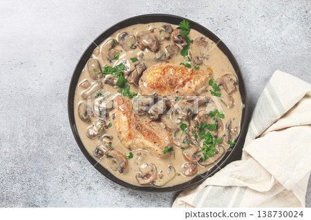 chicken in cream sauce with mushrooms, on a black plate, no people 138730024
