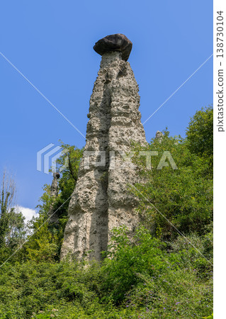 Monumental hoodoo at Pyramids of Zone near Lake Iseo with pale tower and smaller capped spire view 138730104