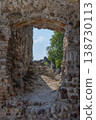 Ancient fortress embrasure in ruined walls of Cavriana Lombardy with sunlit stones and tree beyond 138730113