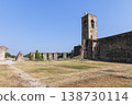 Cavriana castle bell tower and broad courtyard ruins in Lombardy under blue sky with Italian flag 138730114