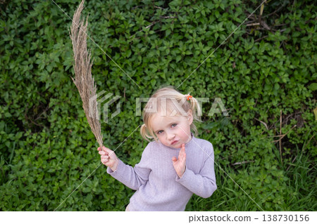 Funny 4 year old girl pulling a silly face while walking in nature Funny 4 year old girl pulling a silly face while walking in nature 138730156