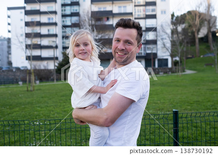Middle-aged father carrying his 4 year old daughter while walking outdoors Middle-aged father carrying his 4 year old daughter while walking outdoors 138730192