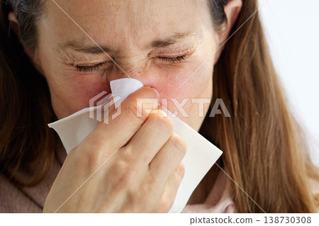 Woman Blowing Nose with Tissue During Cold Woman Blowing Nose with Tissue During Cold 138730308